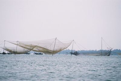 Ship sailing in sea against clear sky