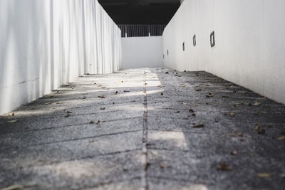 Empty footpath amidst buildings