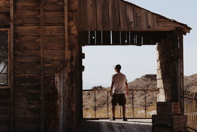 Rear view of man standing against building