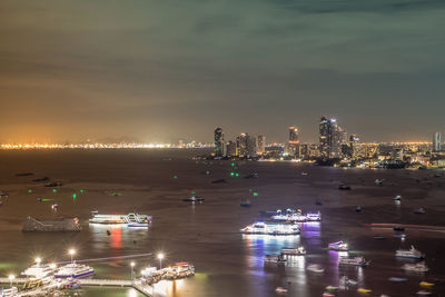 High angle view of illuminated buildings by sea at night