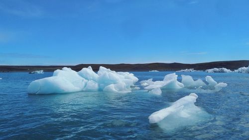 Ice floating on water against sky