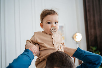 Portrait of cute girl playing with teddy bear at home
