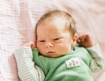 Portrait of cute baby girl lying on sofa