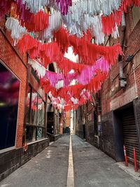 Colorful paper decorations strung between old buildings in lane way in chinatown in the city.