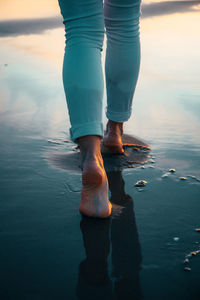 Low section of woman standing on beach