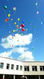 Low angle view of colorful balloons against sky