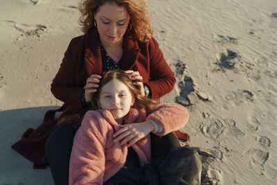 High angle view of girl with her mother on beach