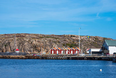 Scenic view of sea by buildings against blue sky