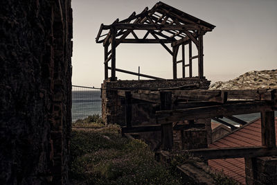 Old metallic structure on sea against clear sky