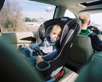 Portrait of happy boy sitting in car