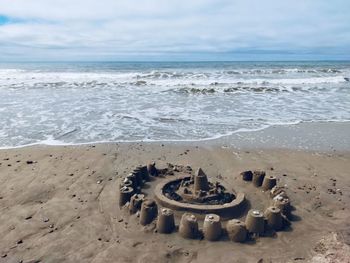 Scenic view of sea against sky with sandcastle on the beach 