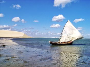 Sailboat on sea against blue sky