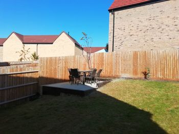 Chairs and houses in yard against sky