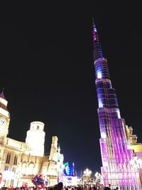 Low angle view of illuminated buildings against sky at night