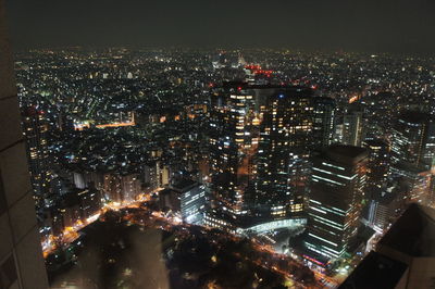 Aerial view of illuminated cityscape against sky at night