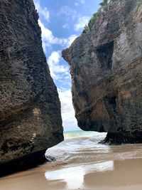 Rock formation on sea shore against sky