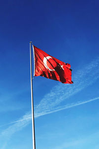 Low angle view of flag against blue sky