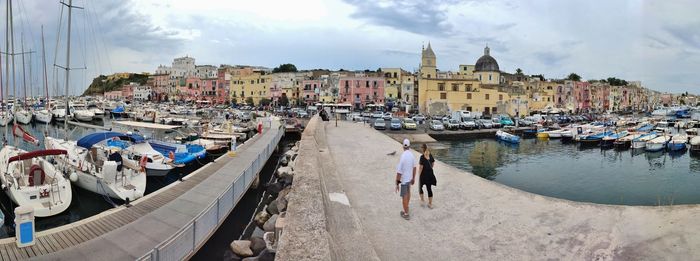 Boats moored at harbor by buildings in city