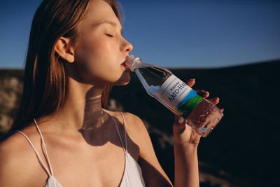 Young woman drinking water from bottle