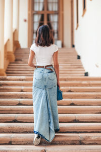 Rear view of woman standing on boardwalk