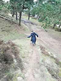 Rear view of man walking on footpath