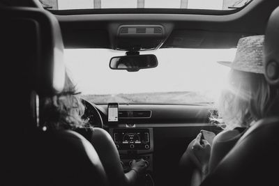 Rear view of women sitting in car