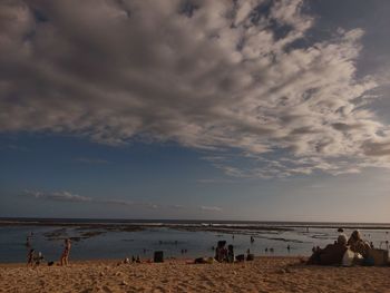 People on beach against sky