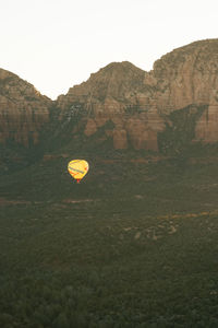 Hot air balloons flying over landscape