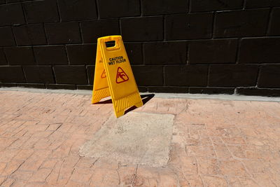 High angle view of yellow sign on wall