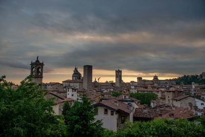 Buildings in city against cloudy sky