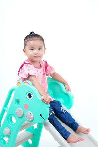 Portrait of cute girl with toy against white background