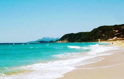 Scenic view of beach against clear blue sky