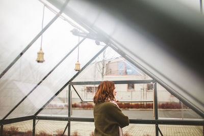 Rear view of woman standing on railing