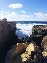 Scenic view of rocks in sea against sky