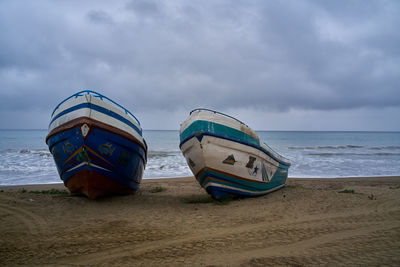 Fisherboat on beach against sky