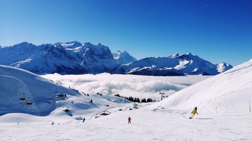 Scenic view of snowcapped mountains against clear blue sky