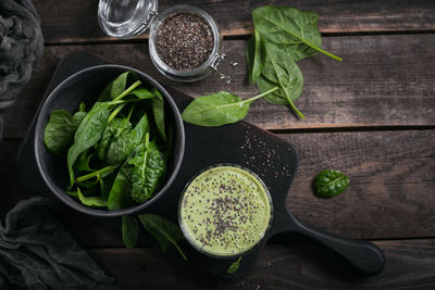 Glass of homemade healthy green smoothie with fresh baby spinach