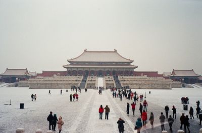 Group of people in front of temple against clear sky