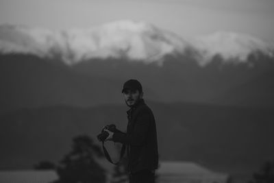 Portrait of man standing against mountains