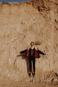 Portrait of young man standing against wall