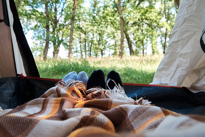 Two people lie in a tourist tent, inside view. feet under the covers in the tent. tourist camp