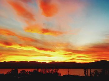 Scenic view of dramatic sky over lake during sunset