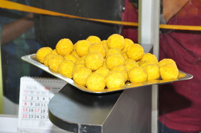 Close-up of yellow laddoos in tray