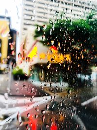 Cars on road seen through wet glass window