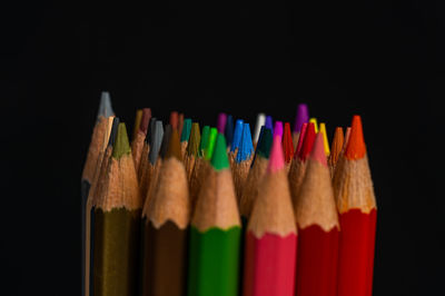 Close-up of colored pencils against black background