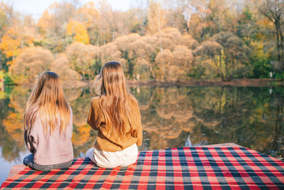 Rear view of two people looking at lake