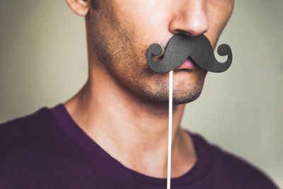 Close-up of man with mustache prop