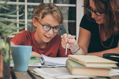 Mother teaching son on table