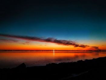 Scenic view of sea against dramatic sky during sunset