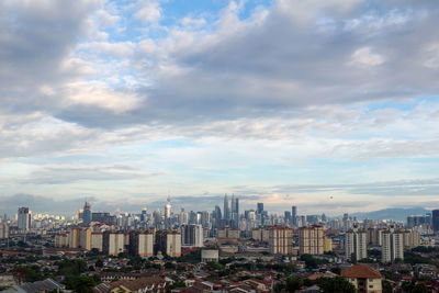 View of cityscape against cloudy sky